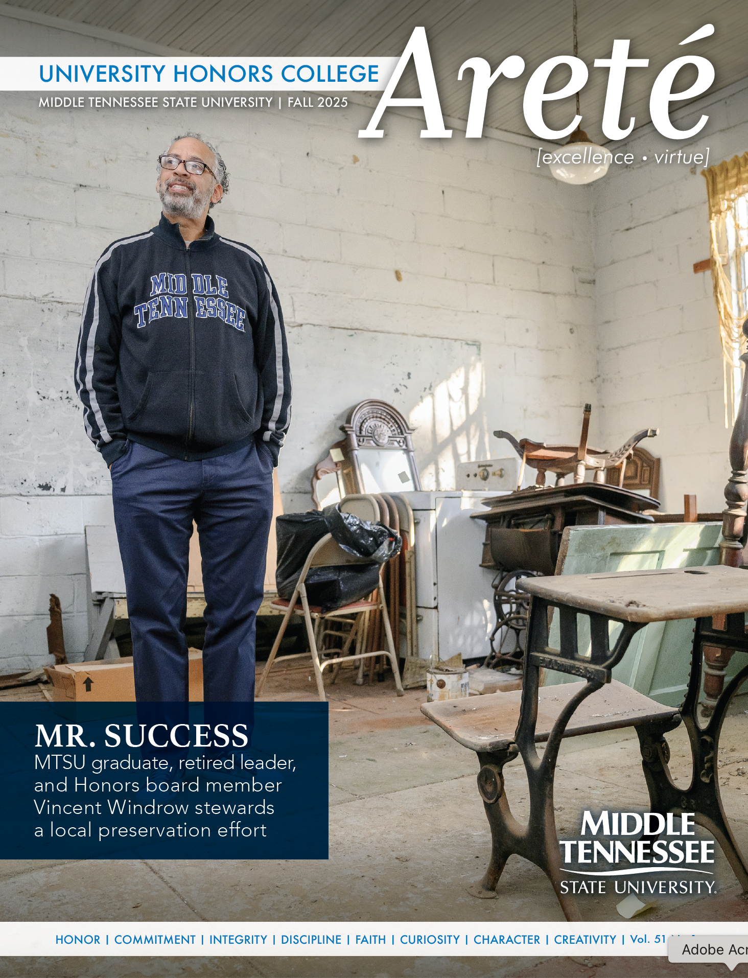 Vincent Windrow stands in an old building filled with old furniture.