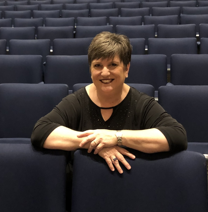 Angela Tipps, MTSU Honors College professor, woman leaning over chair