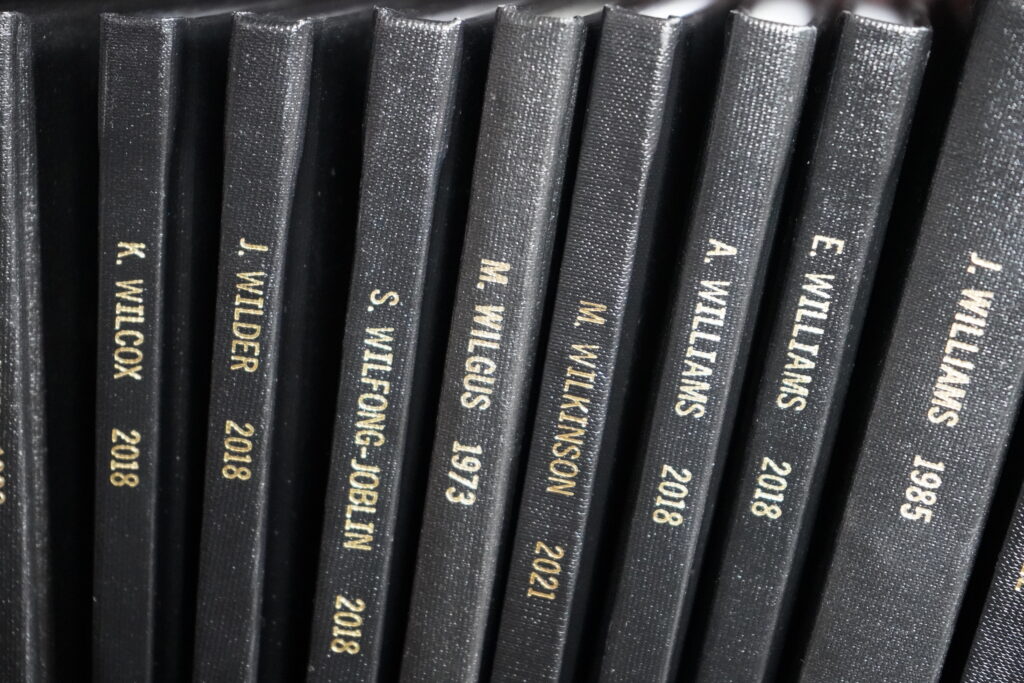 a group of theses books stacked on a shelf, featuring the first MTSU Honors thesis completed in 1973